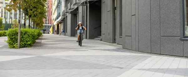 Adorable niñita montando en bicicleta en una ciudad — Foto de Stock