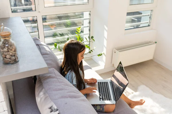 Klein meisje studeren online met behulp van haar laptop thuis — Stockfoto