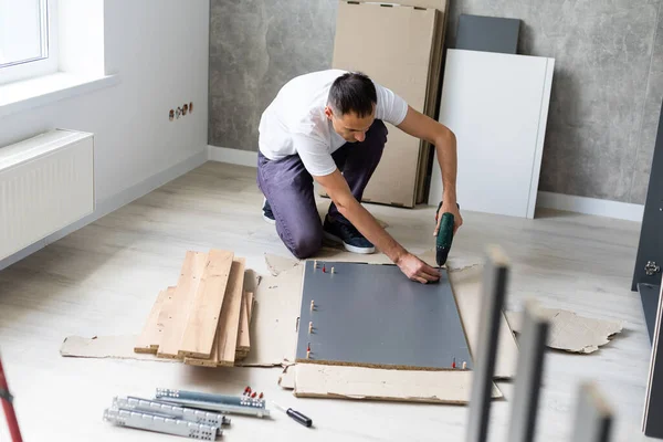 Hombre guapo montando muebles en casa. —  Fotos de Stock