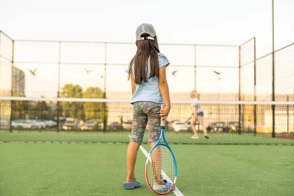 Menina agradável com raquete em mãos jogando jogo de tênis — Fotografia de Stock
