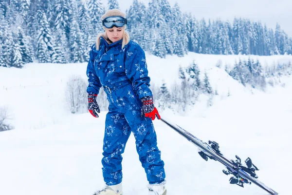 Mulher atraente com esqui sobre fundo de inverno — Fotografia de Stock