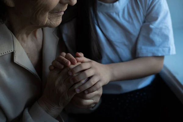 Onherkenbare oma en haar kleindochter die elkaars hand vasthouden. — Stockfoto