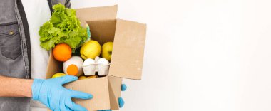 Koruyucu maskeli yemek teslimatçısı.