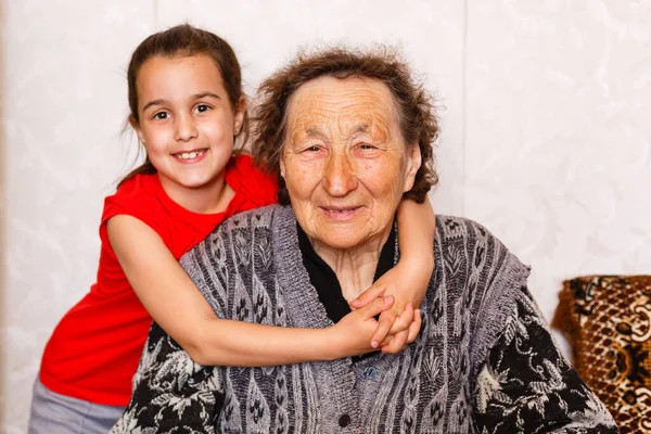 Conceito de ligação familiar. Linda menina feliz emracing sua avó na sala de estar leve — Fotografia de Stock