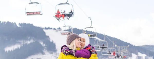 Mãe e filha com snowboards no resort de inverno — Fotografia de Stock