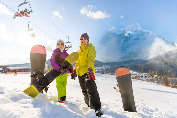 Mutter und Tochter mit Snowboards im Wintersportort — Stockfoto