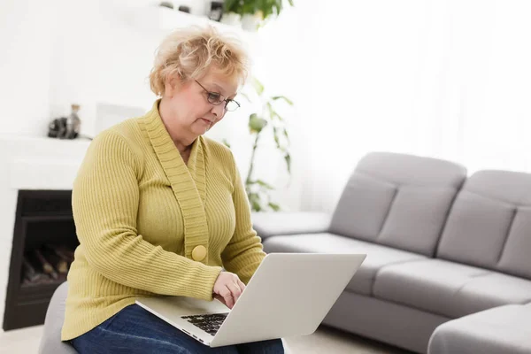 Счастливая Пожилая Женщина Пользуется Ноутбуком Дома — стоковое фото