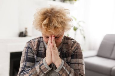 İnançlı, dindar, orta yaşlı bir kadın umut dolu bir inançla dua ediyor. Sabahları evde el ele tutuşup dua eden olgun, inançlı bir Hıristiyan kadın dua ediyor.