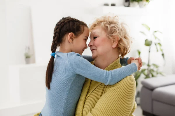 Senior Woman Hugging Granddaughter While Sitting Sofa Home — Stock Photo, Image