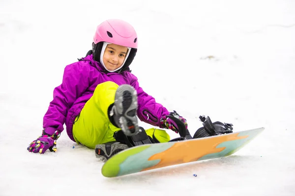小さなかわいい女の子 スキー場でのスノーボード晴れた冬の日 — ストック写真