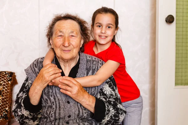 Jovem alegre cuidando de uma mulher idosa em casa — Fotografia de Stock
