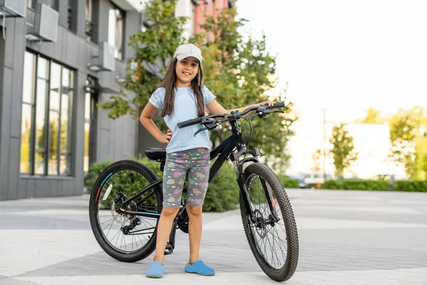 幸せな女の子は街で自転車に乗って — ストック写真