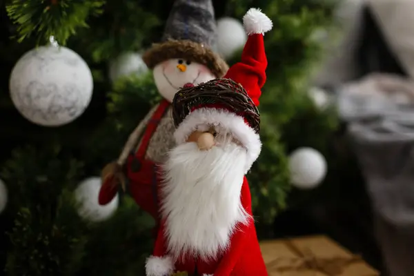 Рождественские зимние каникулы. Украшенная елка, уютный диван с красной подушкой, часы на стене — стоковое фото