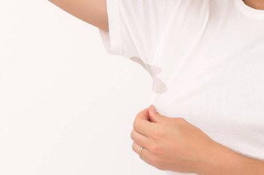 Adam beyaz tişörtünde bir leke gösteriyor.