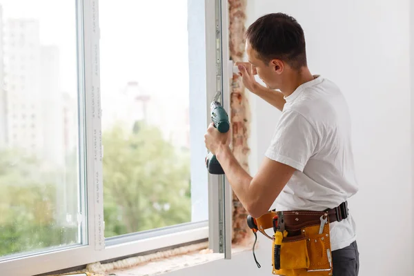 Trabajador constructor industrial masculino en la instalación de ventanas en el sitio de construcción de edificios —  Fotos de Stock