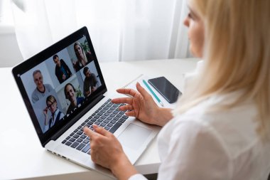 İş kadınlarının iş arkadaşlarıyla video konferansında planlar hakkında konuştuklarını gördüm. Video görüşmesi için laptop kullanan çok ırklı bir iş ekibi. Evden çalışan bir grup zeki insan.
