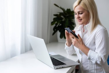 Genç kız kanepede oturup internetten alışveriş yapmayı düşünüyor.