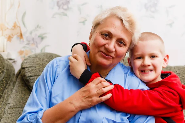 Portret van een gelukkige oma en kleinzoon knuffel — Stockfoto