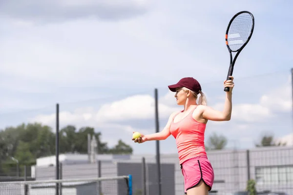 Γυναίκα παίζει τένις κρατώντας μια ρακέτα και χαμογελώντας — Φωτογραφία Αρχείου