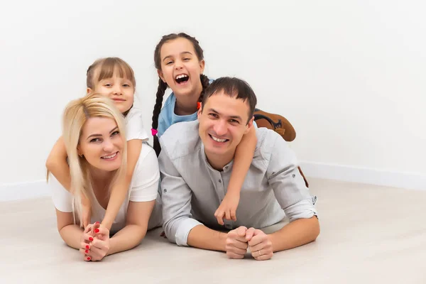 Gelukkige familie zit op houten vloer. Vader, moeder en kind hebben plezier samen. Verhuisdag, nieuw woonconcept — Stockfoto