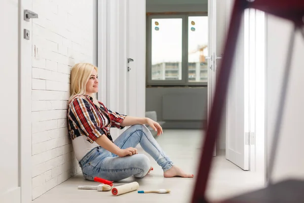 Молодая женщина рисует стену в комнате — стоковое фото