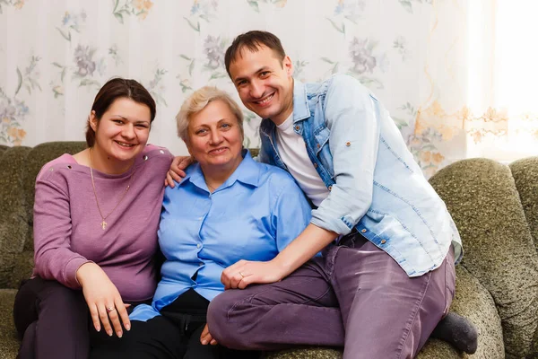 Moeder met volwassen kinderen ontspannen op sofa thuis samen — Stockfoto