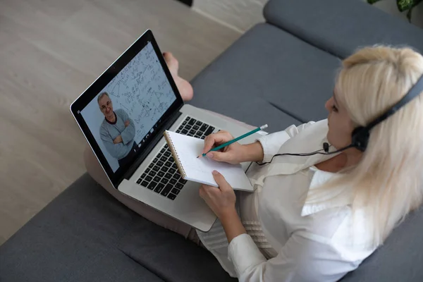 Güzel bir kadın laptopuyla ve kitabıyla dersini eleştiriyor. — Stok fotoğraf