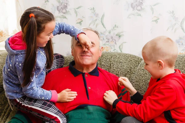 Grand-père passe du temps avec ses petits-enfants dans le salon — Photo