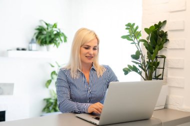 Genç kız kanepede oturup internetten alışveriş yapmayı düşünüyor.