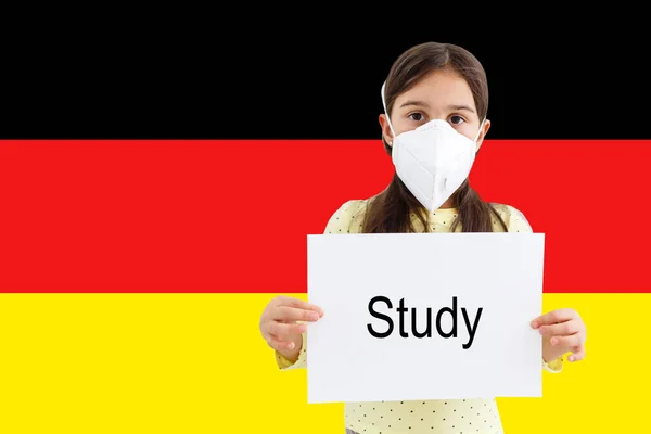Gemaskerd meisje gezicht kijkend naar de camera op vlag Duitsland achtergrond. Het concept van aandacht voor de wereldwijde verspreiding van het coronavirus wereldwijd. Coronavirus, virus in Duitsland. — Stockfoto