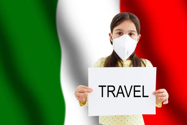 Petite fille en masque facial tenant inscription voyage avec fond de drapeau italien. Épidémie de grippe et concept de protection contre le virus — Photo