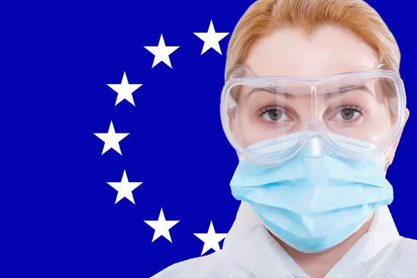 Masked woman face looking at the camera on flag European Union background. The concept of attention to the worldwide spread of the coronavirus worldwide. Coronavirus, virus in EU. — Stock Photo, Image