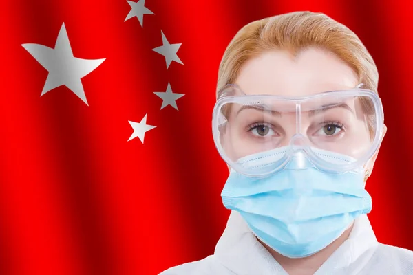 Junge Frau in medizinischer Schutzmaske auf Hintergrund der China-Flagge mit der Aufschrift 2019-nCov, Coronavirus. — Stockfoto