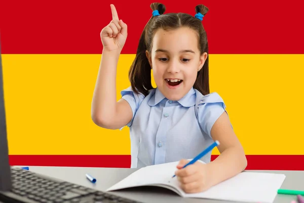 Aprender la lengua europea. Niña inteligente en el fondo de la bandera de España —  Fotos de Stock