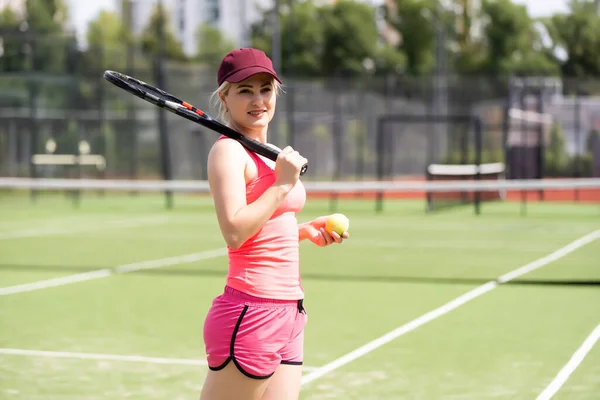 Kvinna som spelar tennis håller ett oväsen och ler — Stockfoto