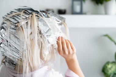 Saçında folyo olan güzel bir kadın. Evde beyazlatma ya da boyama işlemi
