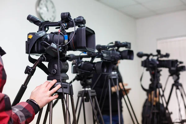 Videocámara profesional, videocámara en trípode, silueta negra sobre fondo azul — Foto de Stock