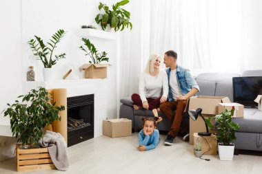 Taşındığı gün yeni evde karton kutuları olan mutlu bir aile..