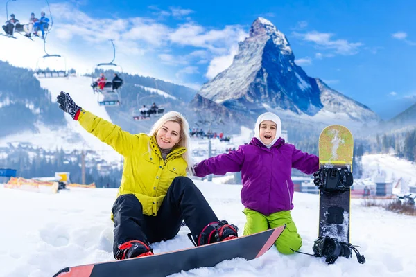 Moeder en dochter met snowboards in een bergresort — Stockfoto