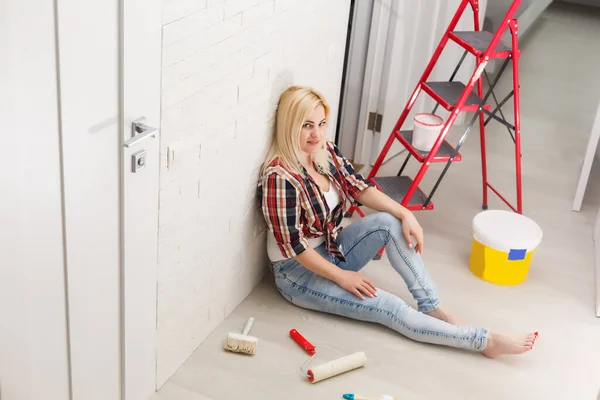 Hermosa joven pintura pared en la habitación — Foto de Stock