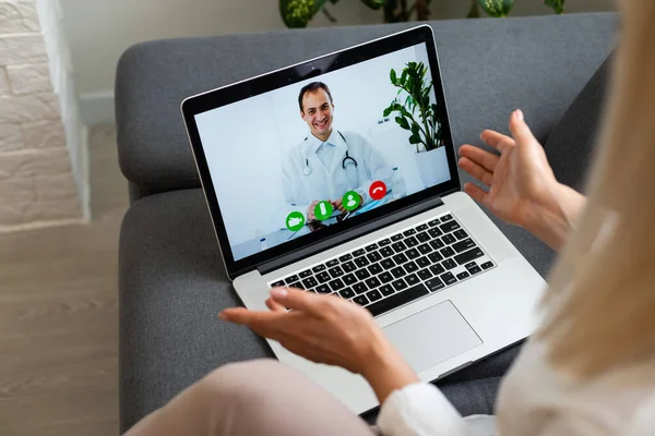 Recadrée vue arrière de la jeune femme dans une pièce lumineuse à l'intérieur confortable appartement à l'aide d'un ordinateur portable pc. Elle parle avec un bon médecin sur Internet — Photo