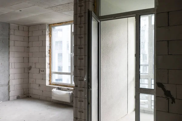 Petit appartement sans réparation dans un immeuble neuf. Une chambre dans une maison inachevée. Murs de bloc de mousse et plancher de béton dans un minuscule appartement. — Photo