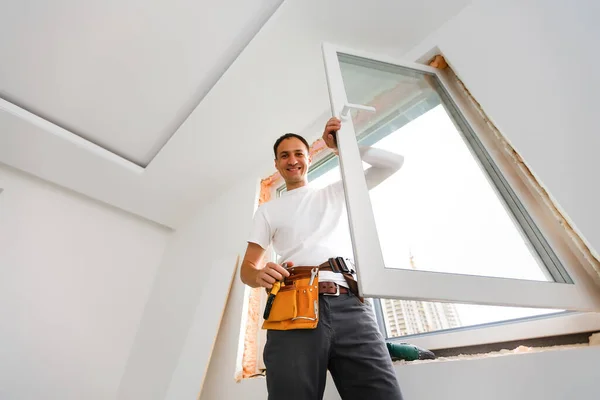 Manlig byggarbetare vid fönsterinstallation på byggarbetsplats — Stockfoto