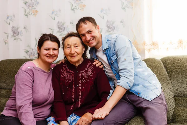 Adulto sorrindo netos abraça avó idosa feliz por ver falta dela, visita de parentes amorosos desfrutar de comunicação, abraçar como símbolo de conexão, amor e conceito de apoio — Fotografia de Stock