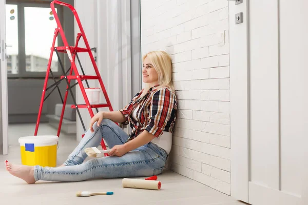 Молодая женщина рисует стену в комнате — стоковое фото