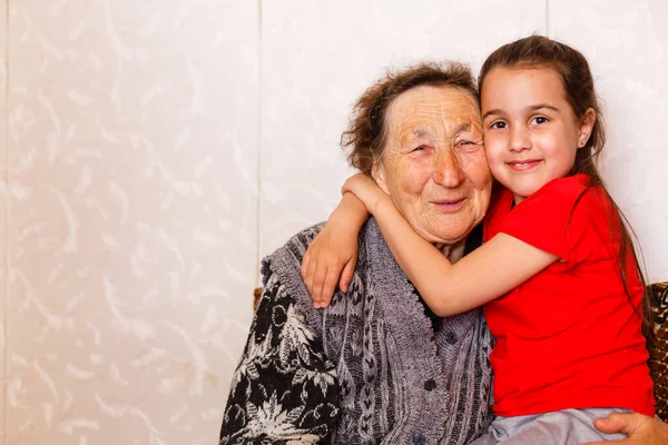 Cheerful young girl taking care of an elderly woman at home — Stock Photo, Image