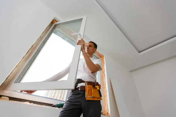 Young handyman repair window with screwdriver