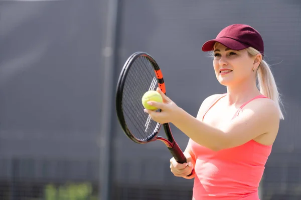 Femme jouant au tennis tenant une raquette et souriant — Photo