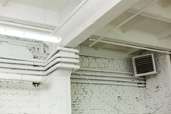벽돌로 만든 두꺼운 벽 질감, 흰 벽돌 벽 그리고 한 쪽 구석에 전기 열 교환기가 있다. Grunge loft 인테리어 디자인 — 스톡 사진