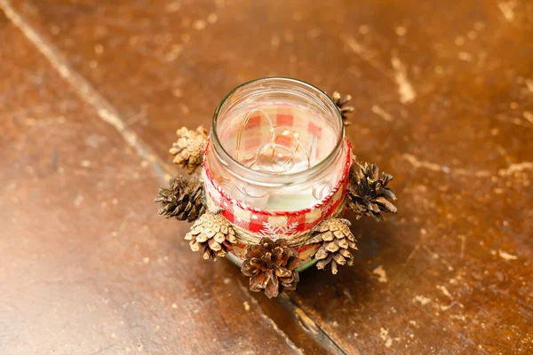 Winter holidays christmas decor. Candescent made of glass jar and pine cones. Top view — Stock Photo, Image